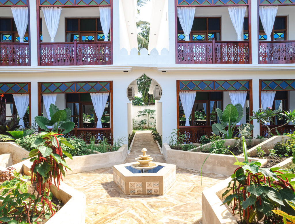 Beautiful garden courtyard with a fountain and balconies at Tasneem Hotel, Jambiani, Zanzibar