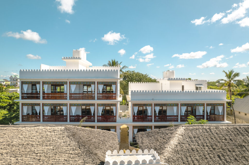 Panoramic view of Tasneem Hotel Zanzibar from a distance, showcasing the lush garden and modern architecture.