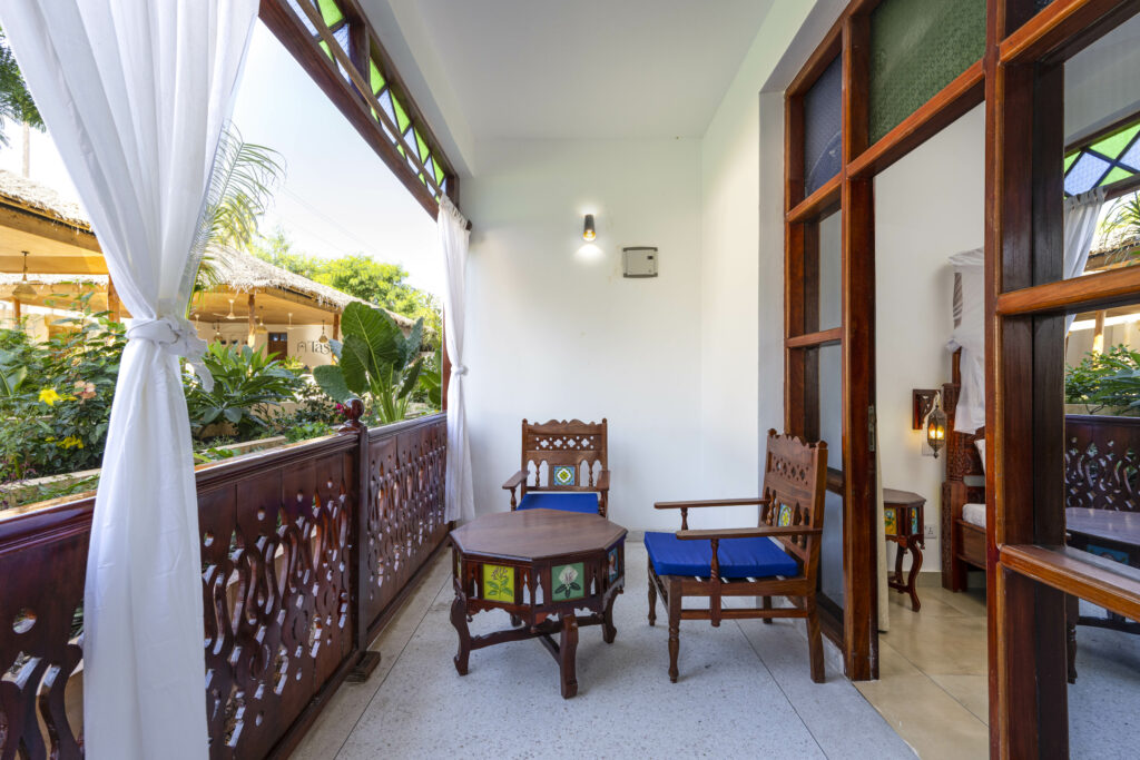 Traditional wooden seating on the balcony with tropical views at Tasneem Hotel, Jambiani, Zanzibar