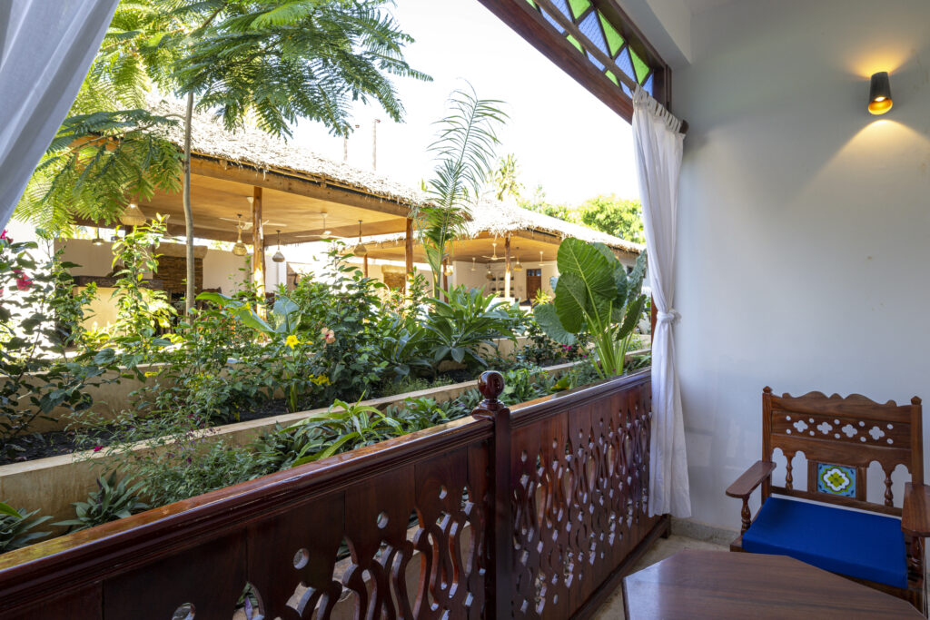 Traditional wooden seating on the balcony with tropical views at Tasneem Hotel, Jambiani, Zanzibar